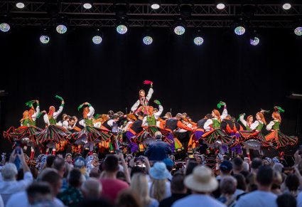 Publiczność i Artyści na scenie w trakcie wykonywania finałowego numeru koncerty