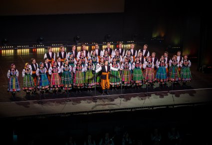 Na scenie Artyści Chóru w kostiumach łowickich podczas śpiewu, przed nimi Solista wykonujący utwór "Furman"