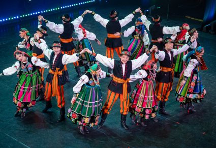 Artyści w kostiumach łowickich podczas śpiewu i wykonywania choreografii tanecznej