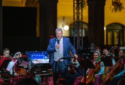 Dyrektor Jacek Boniecki podczas przemowy na scenie a w tle orkiestra