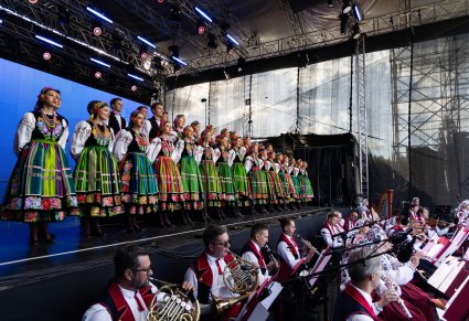 Na scenie Artyści Chóru w kostiumach łowickich, niżej Artyści Orkiestry w kostiumach wilanowskich
