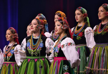Zbliżenie na Solistki z Chóru w kostiumach łowickich, w tle pozostałe Artystki Chóru