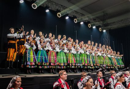 Na scenie klaszczący Artyści Chóru w kostiumach łowickich