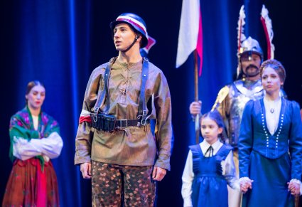 Zbliżenie na postać Powstańca 1944, w tle pozostała część postaci grająca w spektaklu