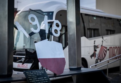 Pomnik a w tle autokar "Mazowsze"