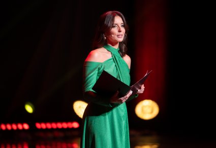 Zbliżenie na konferansjerkę w długiej zielonej sukni