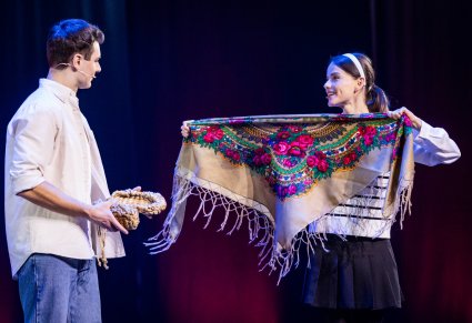 Tomek i Agnieszka trzymający elementy kostiumu ludowego, chustę i buty