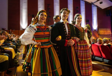 Zbliżenie na Artystów w kostiumach ludowych w trakcie interakcji z publicznością