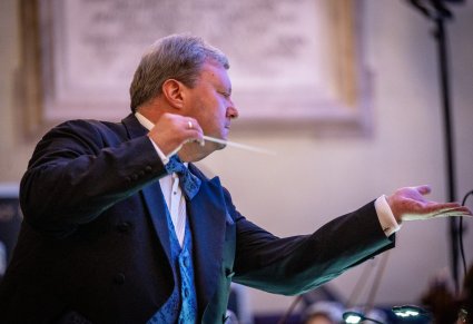 Zbliżenie na Dyrektora Jacka Bonieckiego w trakcie dyrygowania koncertu