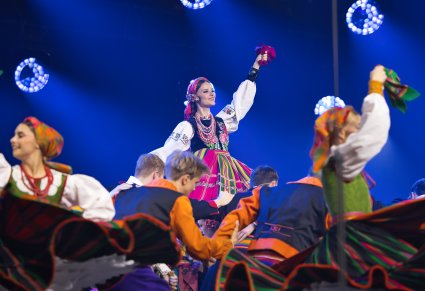 Zbliżenie na Artystów w kostiumach ludowych w trakcie wykonywania choreografii tanecznej
