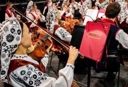 Zbliżenie na Artystów orkiestry w kostiumach wilanowskich grających na Instrumentach smyczkowych