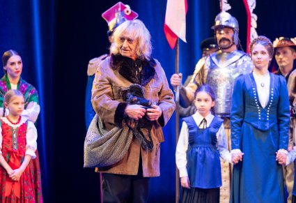 Zbliżenie na postać Sybiraka, w tle część Artystów grająca w tej scenie