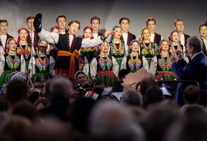 Solista chóru i część chóru w kostiumach łowickich, podczas wykonywania "Furmana"