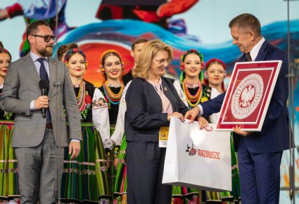 Zbliżenie na mera rejonu solecznickiego wraz z przedstawicielami Samorządu Województwa Mazowieckiego, w tle część Artystów w kostiumach łowickich