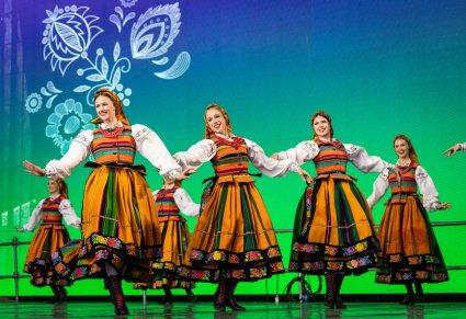 Zbliżenie na Artystki w kostiumach łowickich w trakcie wykonywania choreografii tanecznej