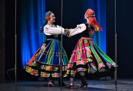 Para Artystek w kostiumach łowickich w trakcie wykonywania choreografii tanecznej
