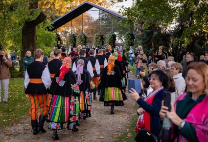 Artyści Mazowsza w kostiumach łowickich po koncercie, przechodzący wśród publiczności
