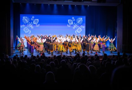 Na scenie Artyści w kostiumach ludowych w trakcie wykonywania finałowej choreografii
