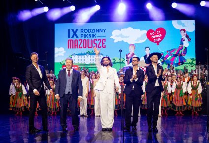 Na środku sceny Dyrektor zespołu "Mazowsze" wraz z grupą Pectus, w tle Artyści w kostiumach ludowych