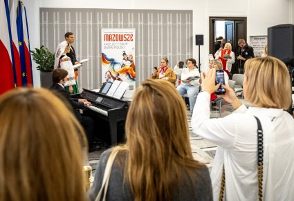 Artyści w trakcie śpiewu, Akompaniator i uczestnicy wspólnego śpiewania pieśni patriotycznych