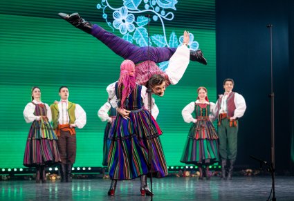 Na pierwszym planie para Artystów w kostiumach opoczyńskich w trakcie wykonywania figur akrobatycznych