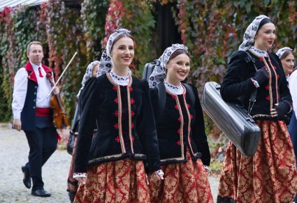 Część orkiestry w kostiumach wilanowskich w drodze do namiotu koncertowego