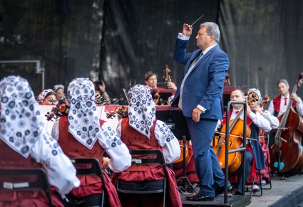 Dyrektor Jacek Boniecki dyryguje orkiestrę na scenie
