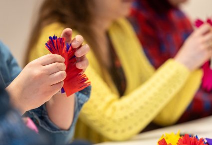 Zbliżenie na tworzenie kwiatów z bibuły na warsztatach rękodzielniczych w Pałacu w Karolinie