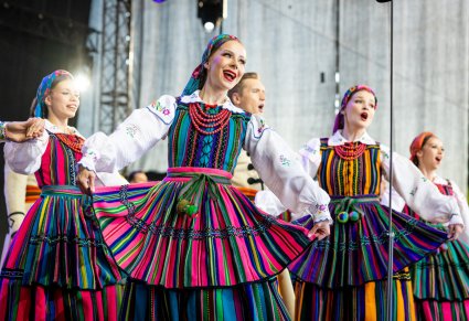 Grupa Artystek w kostiumach opoczyńskich w trakcie śpiewu i wykonywania choreografii