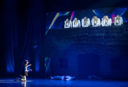 Na pierwszym planie Anioły Dachowe a pod szopką klęcząca postać Pasterza i leżące postaci innych Pasterzy