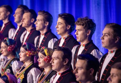 Zbliżenie na chórzystów Mazowsza w kostiumach łowickich