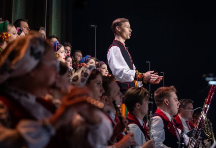 Solista Mazowsza w kostiumie łowickim śpiewa