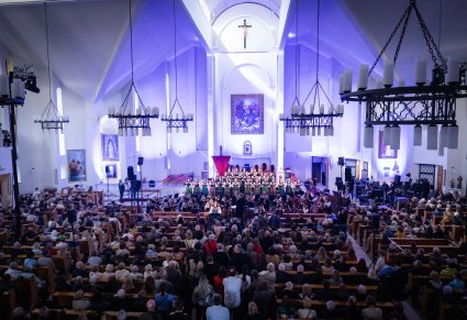 Koncert w kościele, widoczny chór, solistki, orkiestra i widownia