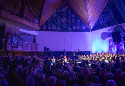 Koncert w kościele, widoczny chór, solistki, orkiestra i widownia