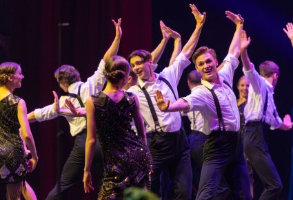 Zbliżenie na Artystów Baletu w strojach stylizowanych na lata 20ste w trakcie wykonywania choreografii tanecznej