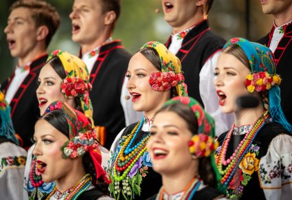 Zbliżenie na Artystów z chóru w kostiumach łowickich
