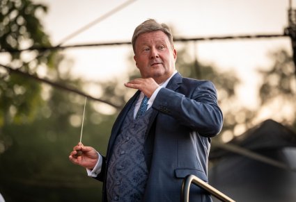 Zbliżenie na dyrektora Jacka Bonieckiego w trakcie dyrygowania