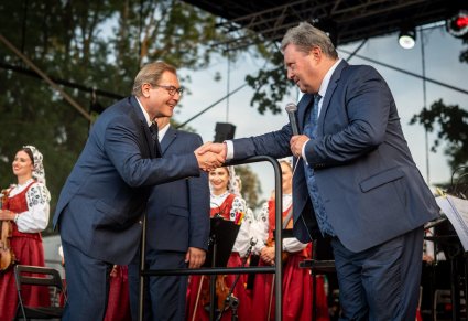 Dyrektor Jacek Boniecki uciskający dłoń Mirosława Ziomka na scenie, w tle orkiestra