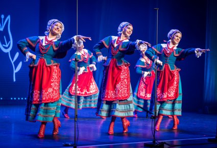 Grupa artystek zespołu "Mazowsze" w kostiumach kujawskich na scenie