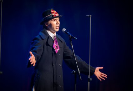 Śpiewający uczestnik gali na scenie w kostiumie bamberskim