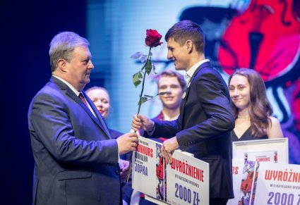 Dyrektor Jacek Boniecki wręczający nagrodę uczestnikowi gali na scenie