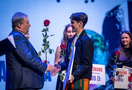 Dyrektor Jacek Boniecki wręczający nagrodę uczestnikowi gali na scenie