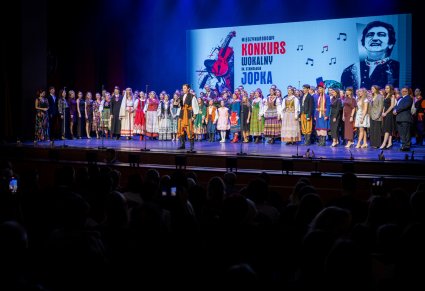 Solista w roli Furmana śpiewa a za nim stoją uczestnicy gali