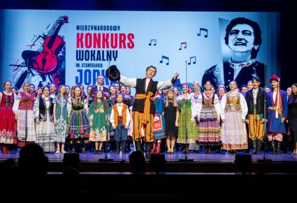 Solista w roli Furmana śpiewa a za nim stoją uczestnicy gali