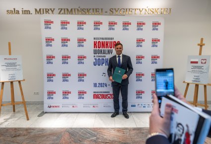 Emil Sawicki robiący zdjęcie na ściance