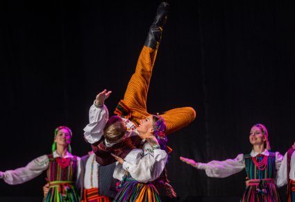 Artystka podnosząca Artystę wykonując wspólnie figurę taneczną, obydwoje są w kostiumach opoczyńskich