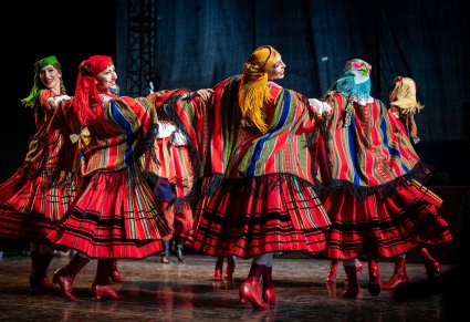 Artystki w kostiumach sieradzkich na scenie w choreografii tanecznej