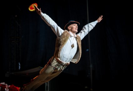 Artystka w kostiumie jurgowskich wykonujący choreografię taneczną na scenie