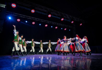 Artyści w kostiumach spiskich na scenie wykonujący choreografię taneczną