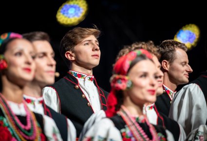Zbliżenie na Artystów z chóru w kostiumach łowickich